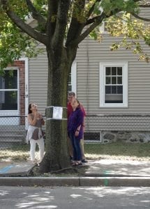 Adams Stpedestrians read notice | Village 14 Pedestrians on Adams Street read one of the Tree Removal hearing notices Photo by Julia Malakie